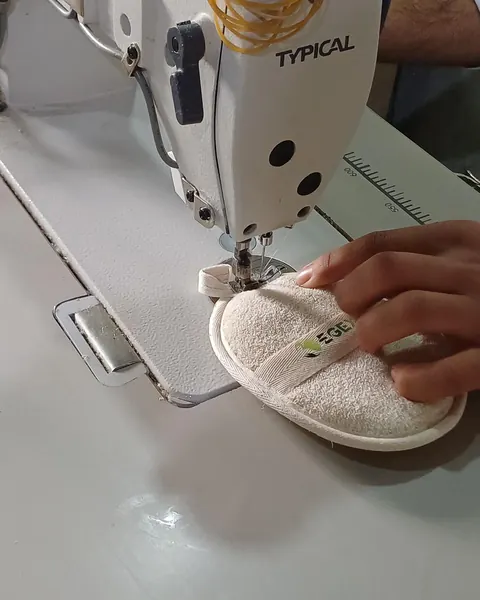 A loofah pad sewn with cotton edging on a sewing machine