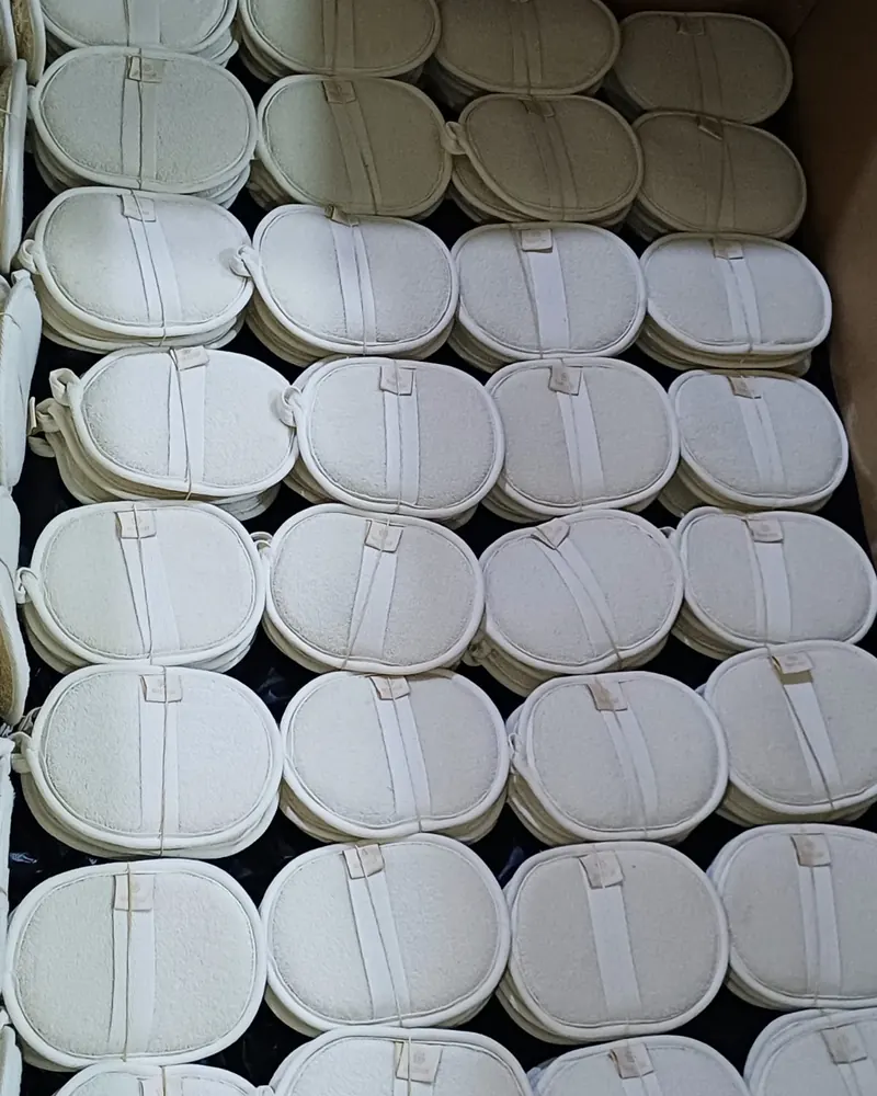 Oval loofah pads packed in rows in a carton